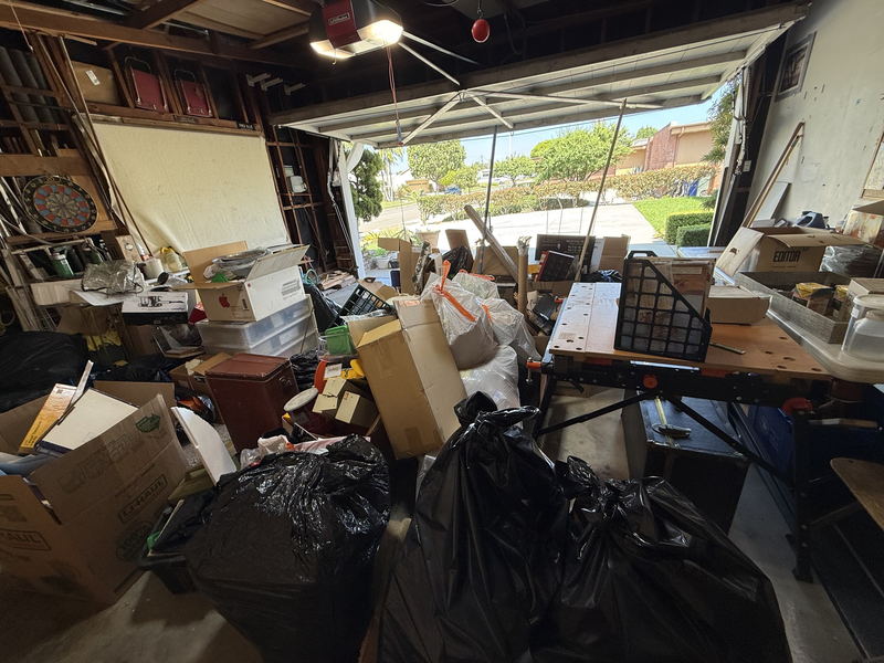 A Los Angeles County garage packed shoulder-high with cartons, bulging black bags, storage crates and tools, only a narrow path left to the open roller door