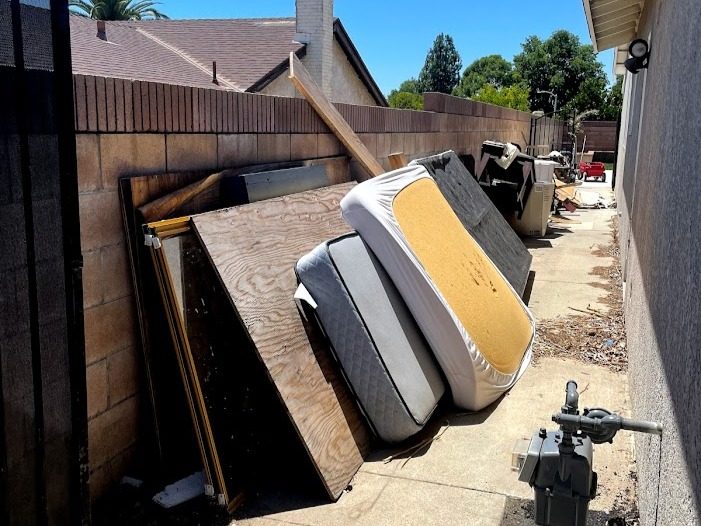 Mattresses and household debris in a side yard